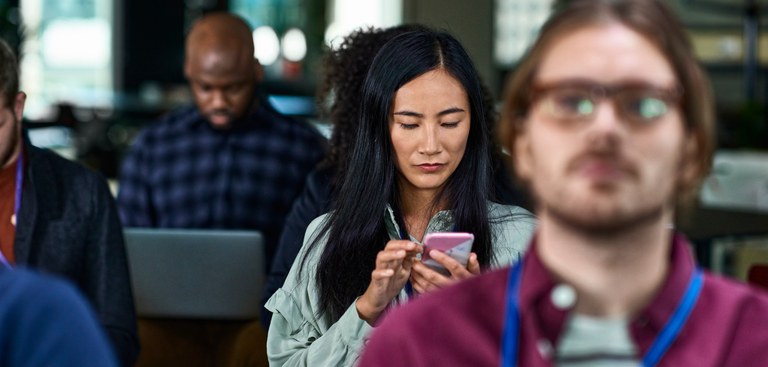 Entre diferentes pessoas uma mulher utiliza o celular.jpg Entre diferentes pessoas uma mulher utiliza o celular.jpg